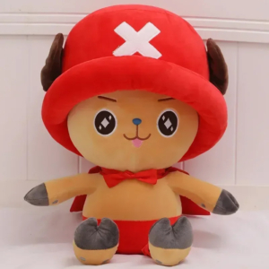 Peluche one piece Chopper avec une cape posée devant un panneau blanc en bois