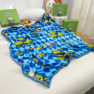 Plaid Disney avec imprimé d'extraterrestres verts posé sur un lit