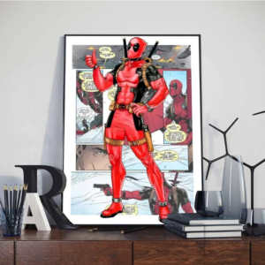 Tableau marvel Dead Pool style affiche imprimé posé sur un meuble marron devant un mur gris avec des livres, des crayons, des lettres et des verres autour